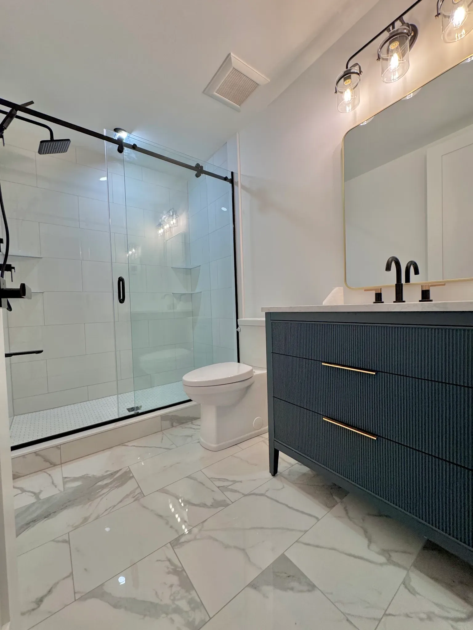 washroom with blue vanity black and gold mixed faucets black light