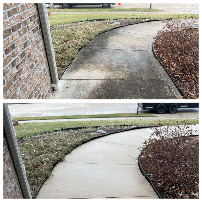 Before-and-after sidewalk cleaning: stained concrete walkway beside a brick wall becomes bright and clean.