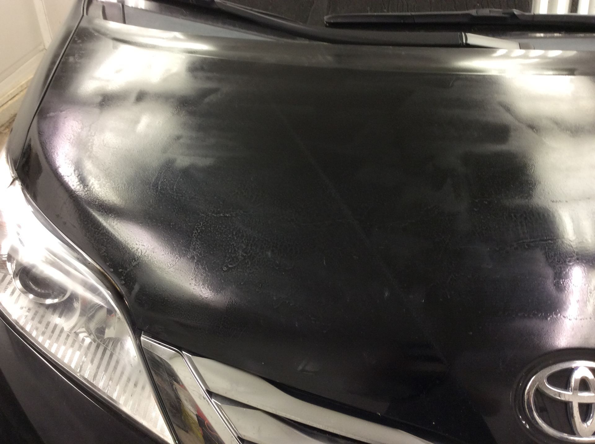A close up of the hood of a black toyota