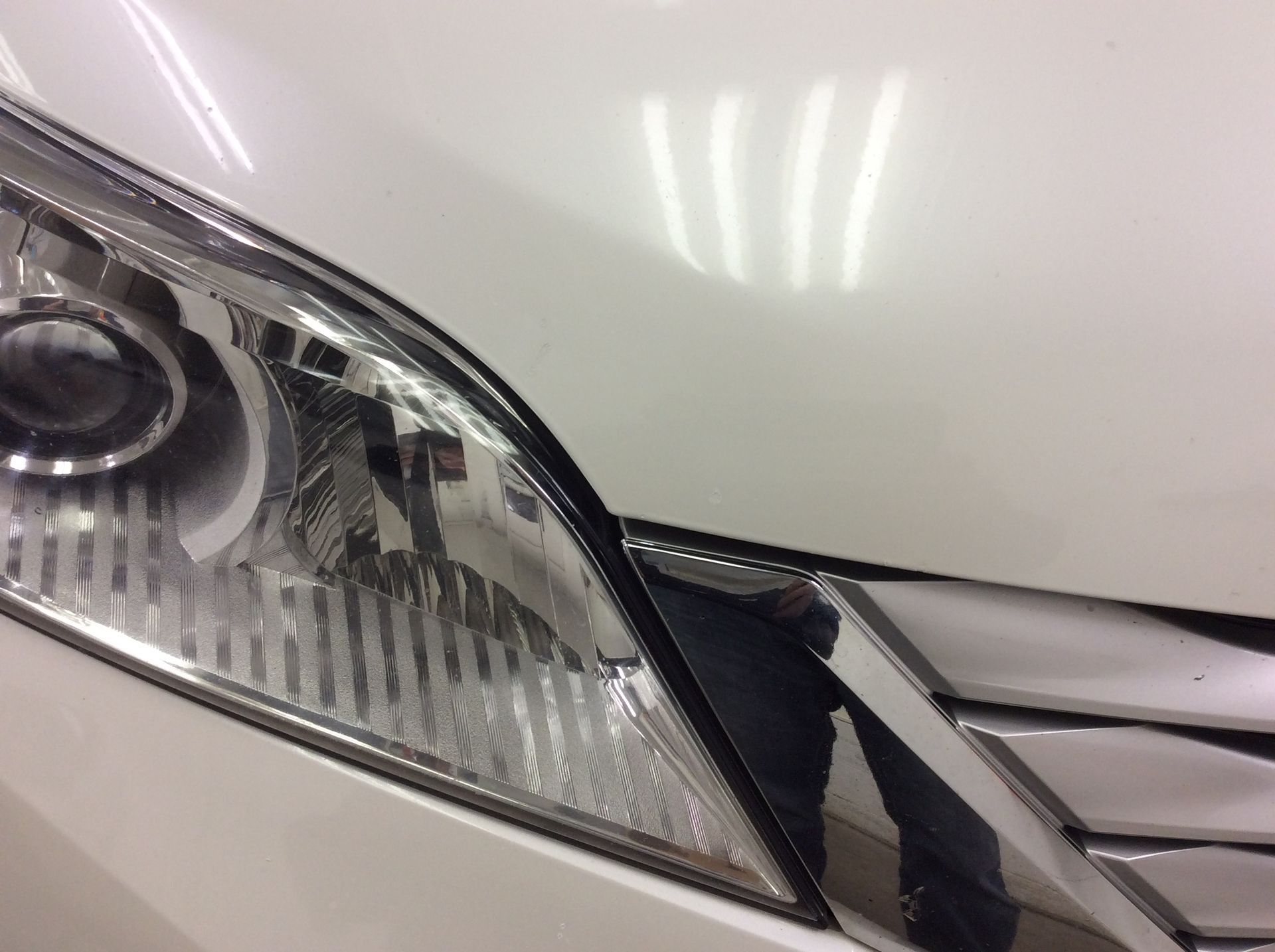 A close up of the headlight of a white car