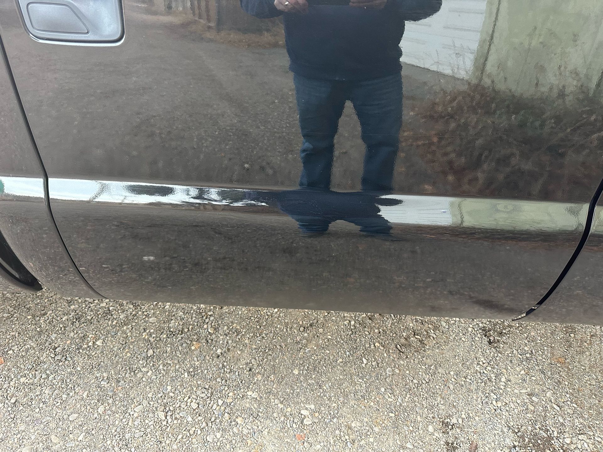 A man is taking a picture of himself in the mirror of a car