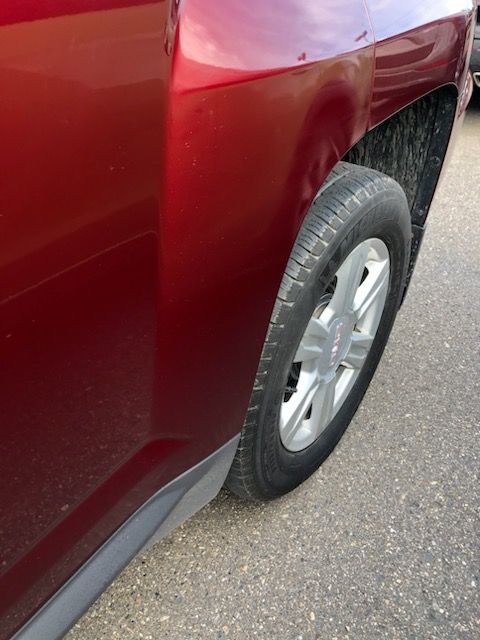 A red car is parked on the side of the road