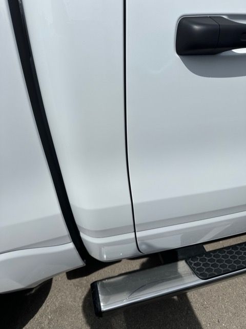 A white truck with a black handle and side step
