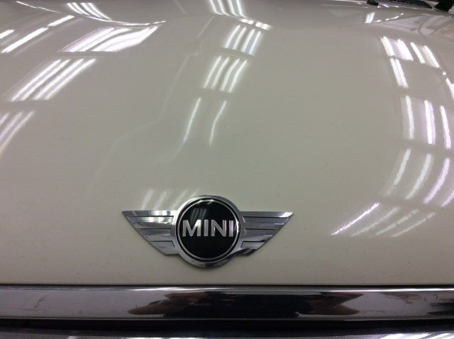 A close up of the hood of a white mini cooper