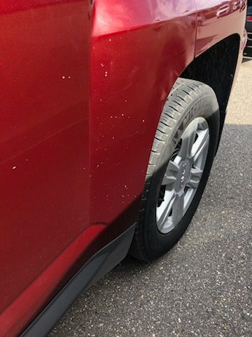 A red car is parked on the side of the road.