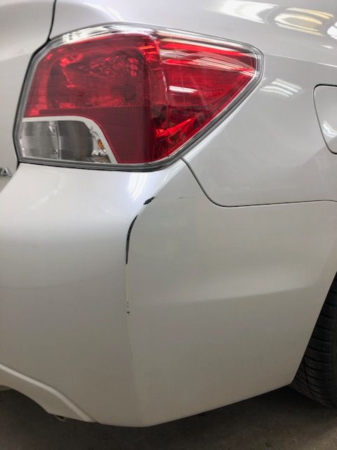 A close up of a white car with a red tail light