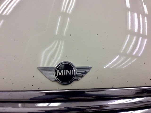 A close up of a white mini car emblem