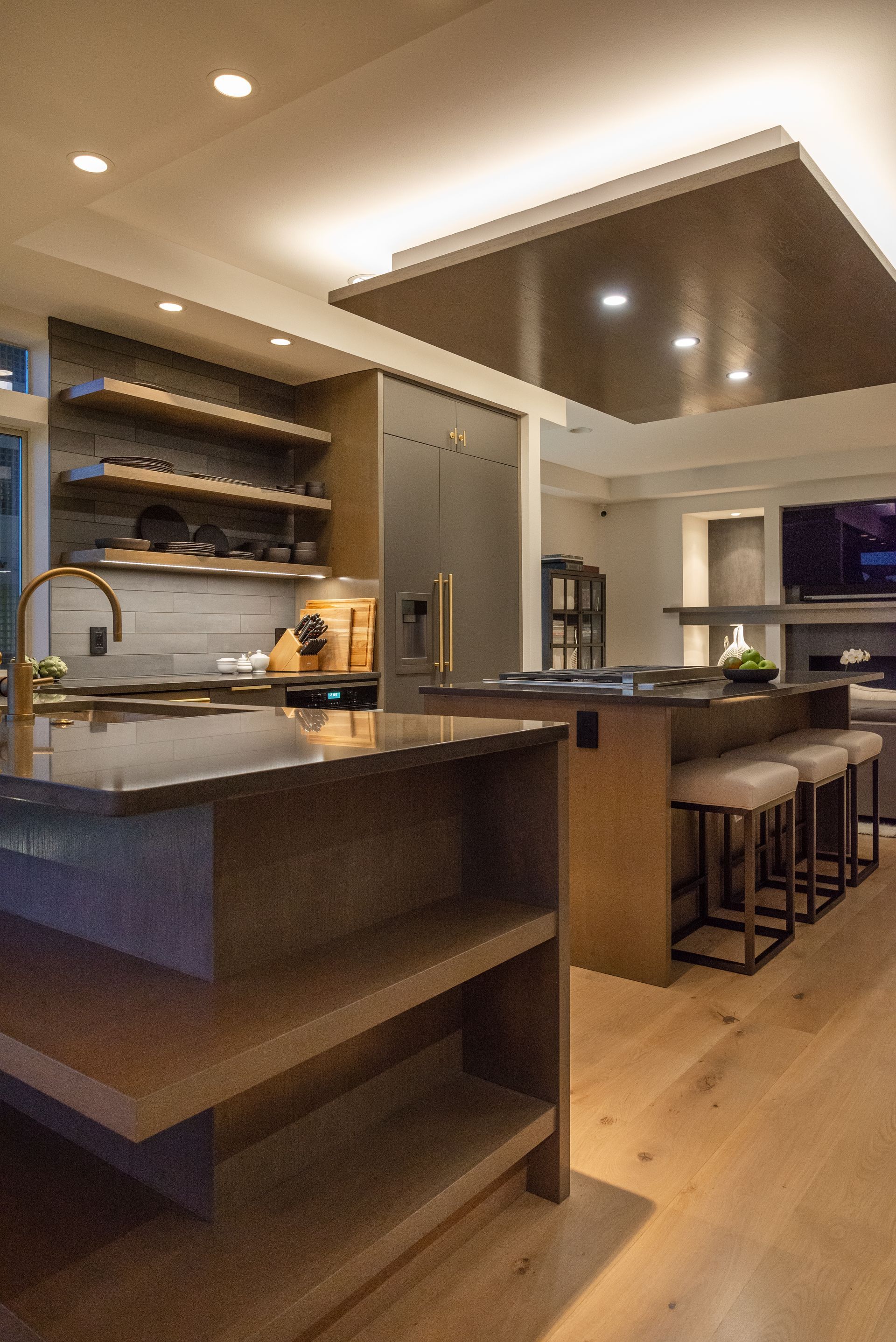 Modern kitchen interior with island, bar stools, and recessed ceiling lighting