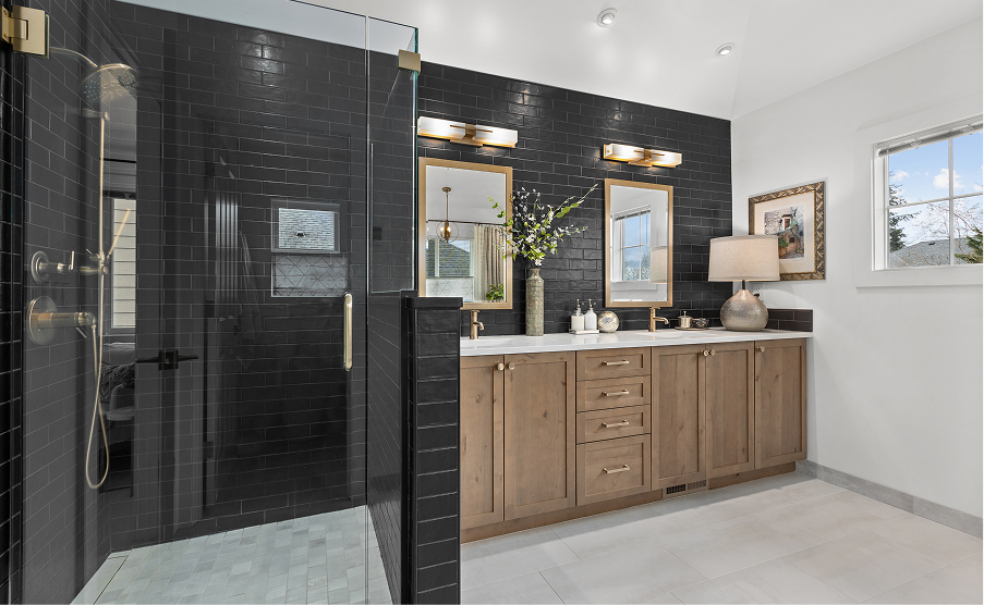 Modern bathroom with black glass shower, wood vanity, double sinks, and wall mirror under bright lighting