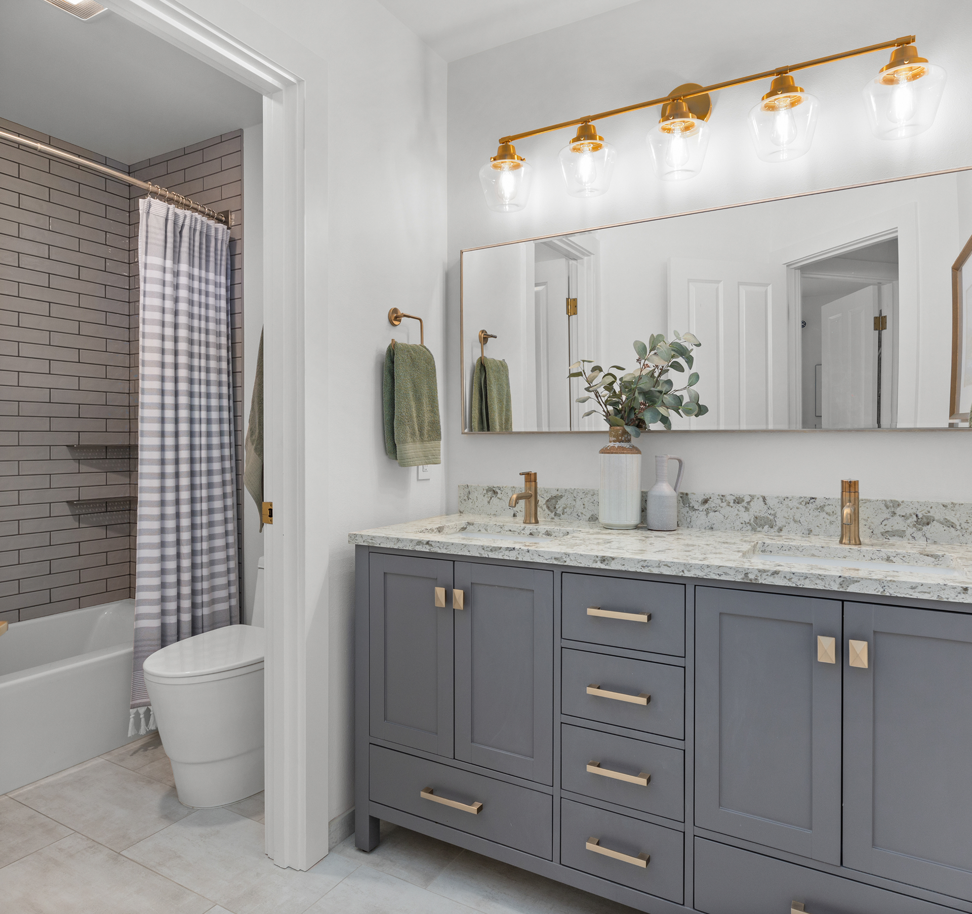 Modern bathroom with glass shower, hexagonal mirror, and marble sink vanity