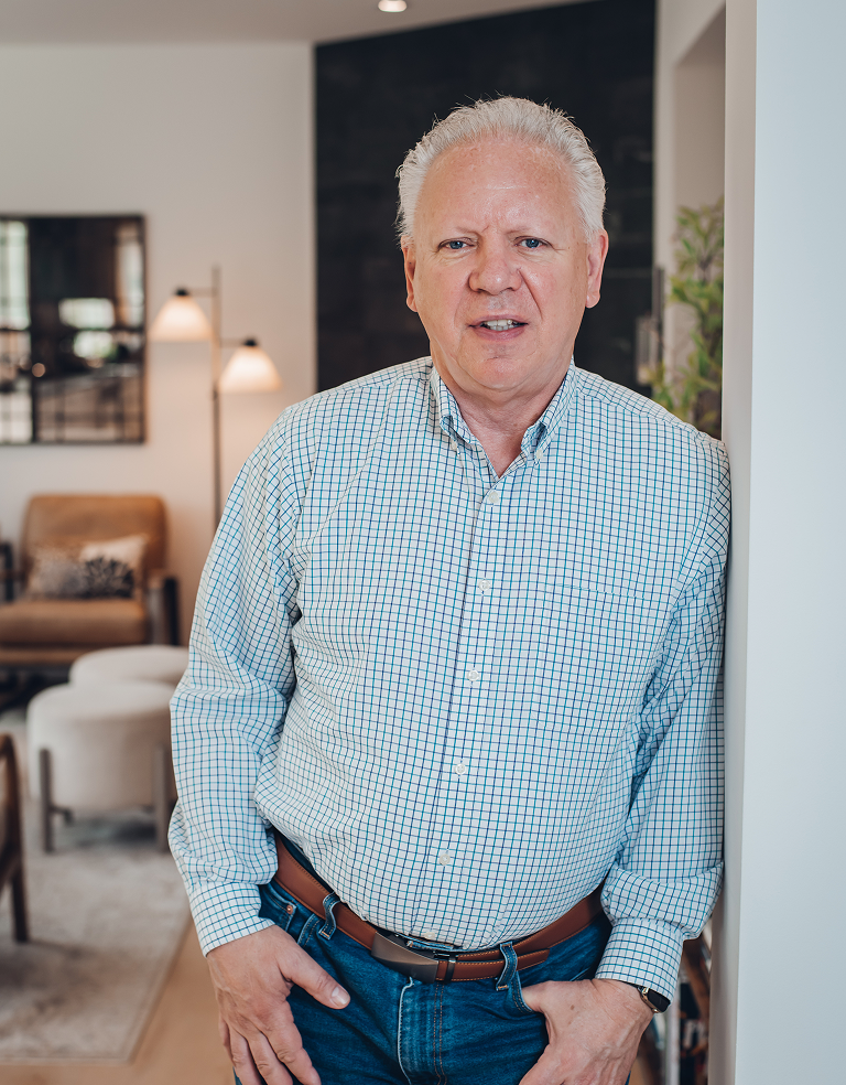 Bill Olson standing indoors in a modern living room