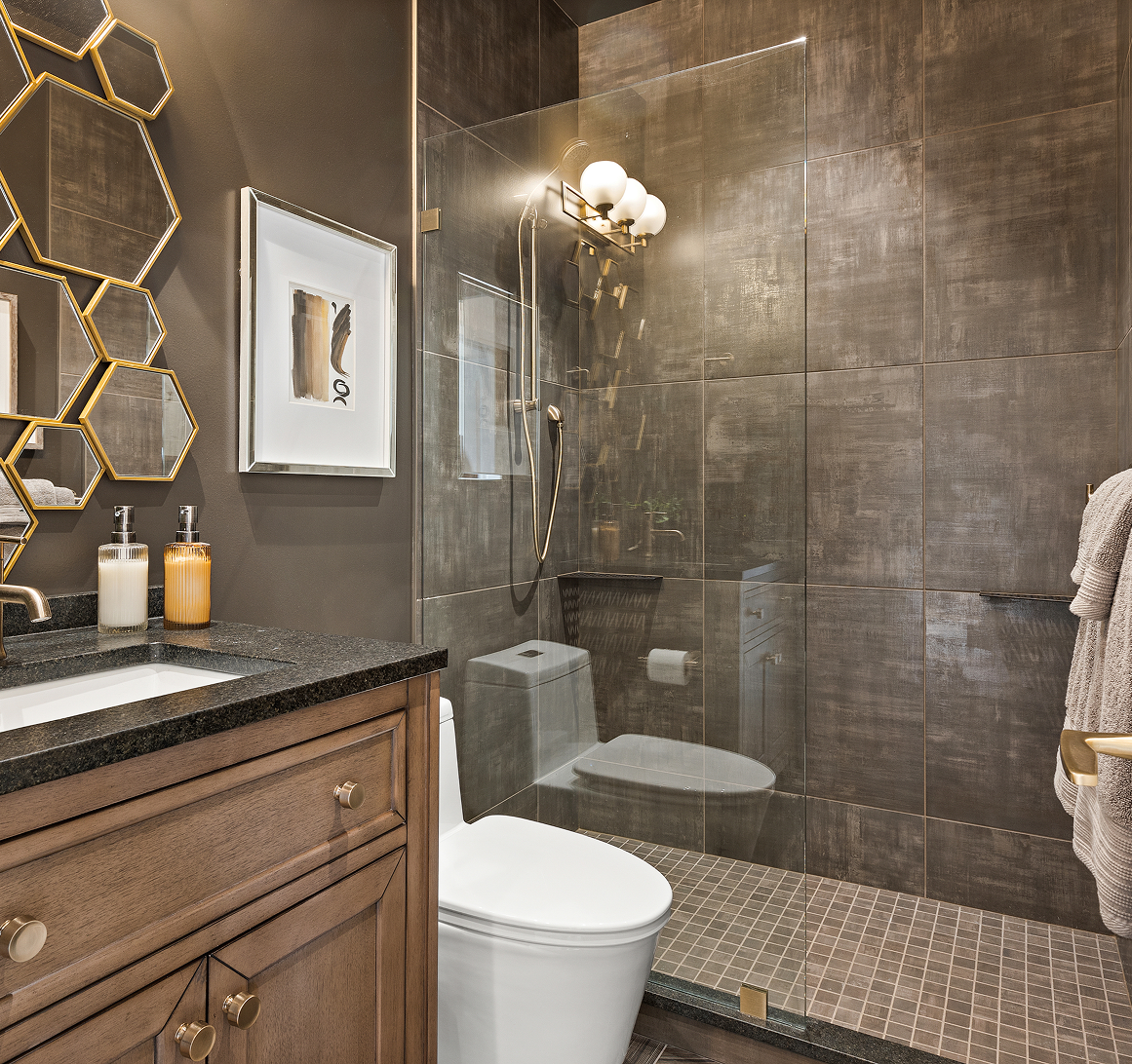 Modern bathroom with glass shower, hexagonal mirror, and marble sink vanity