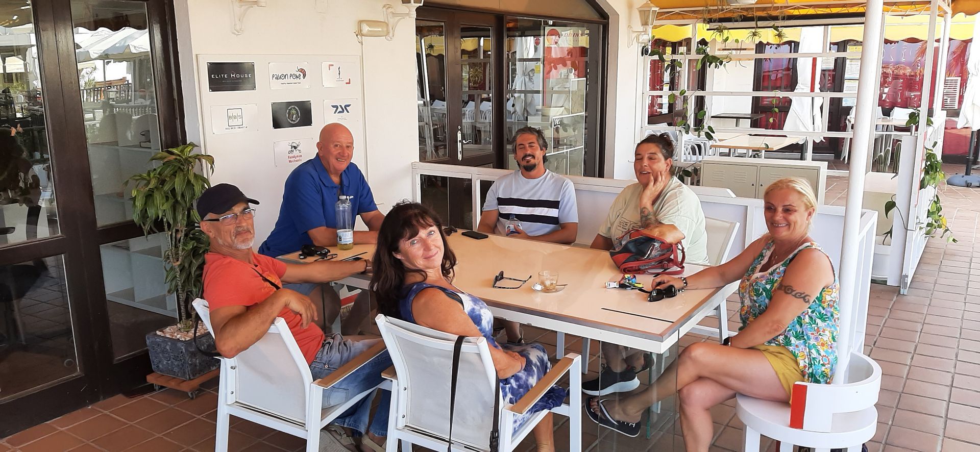 A group of people are sitting around a table in a restaurant.
