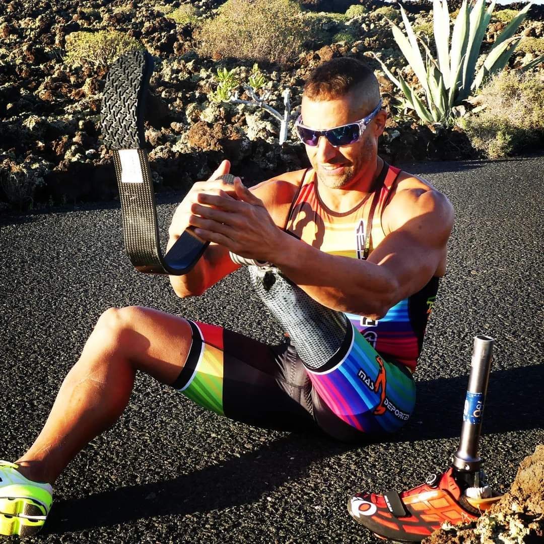 A man with a prosthetic leg is sitting on the ground