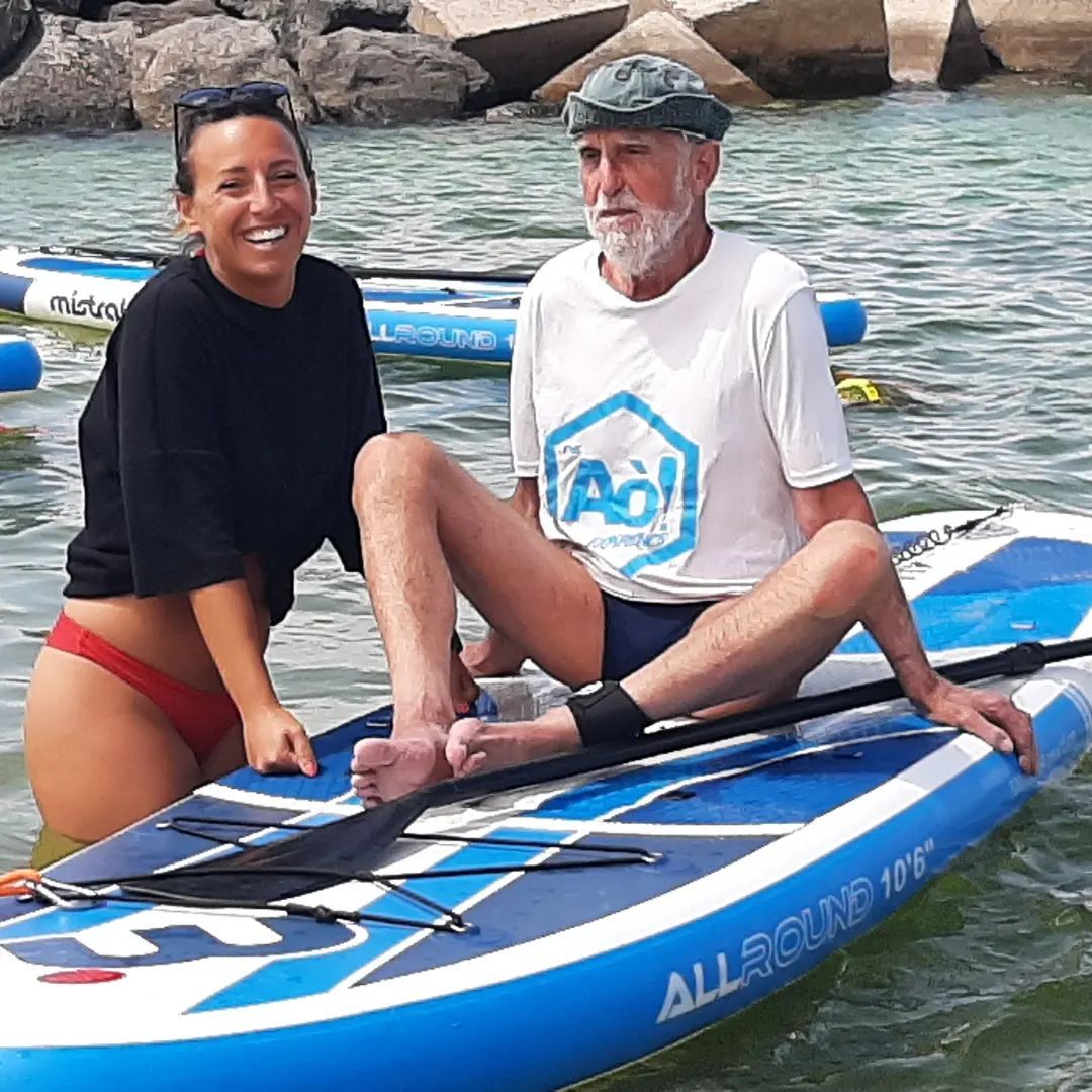 A man and a woman are sitting on a paddle board in the water