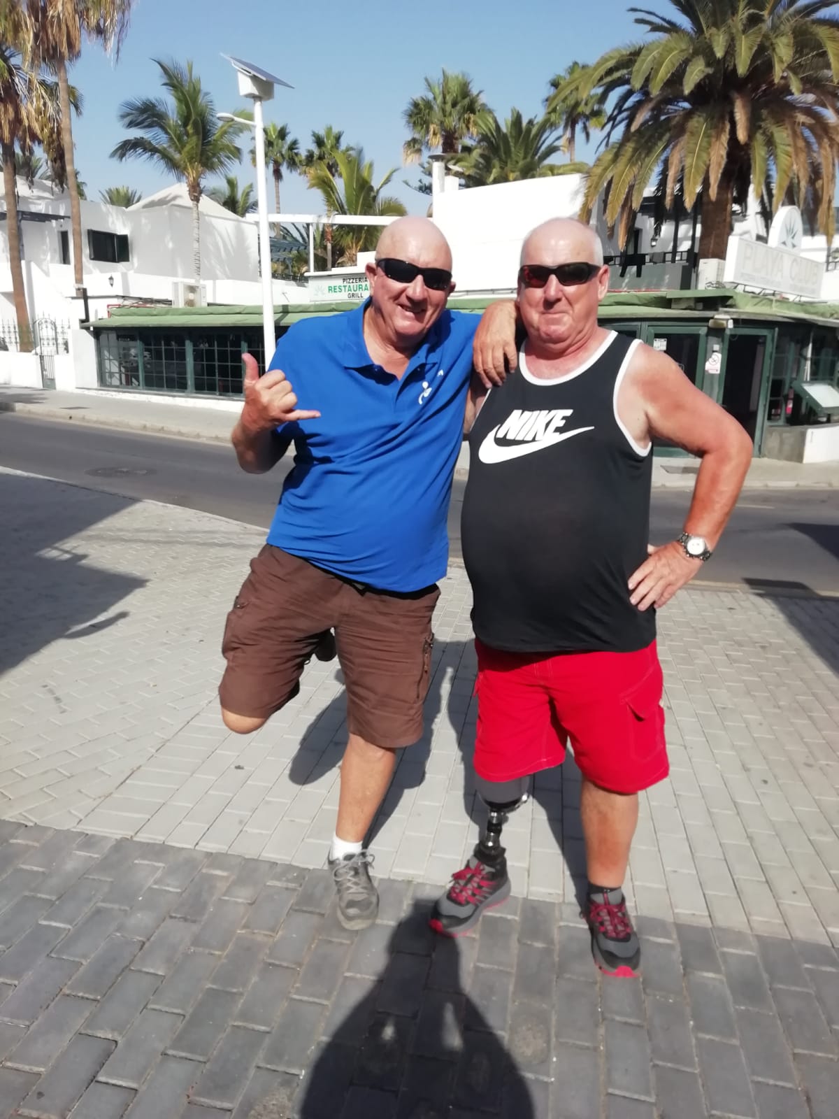 Two men standing next to each other one wearing a nike tank top