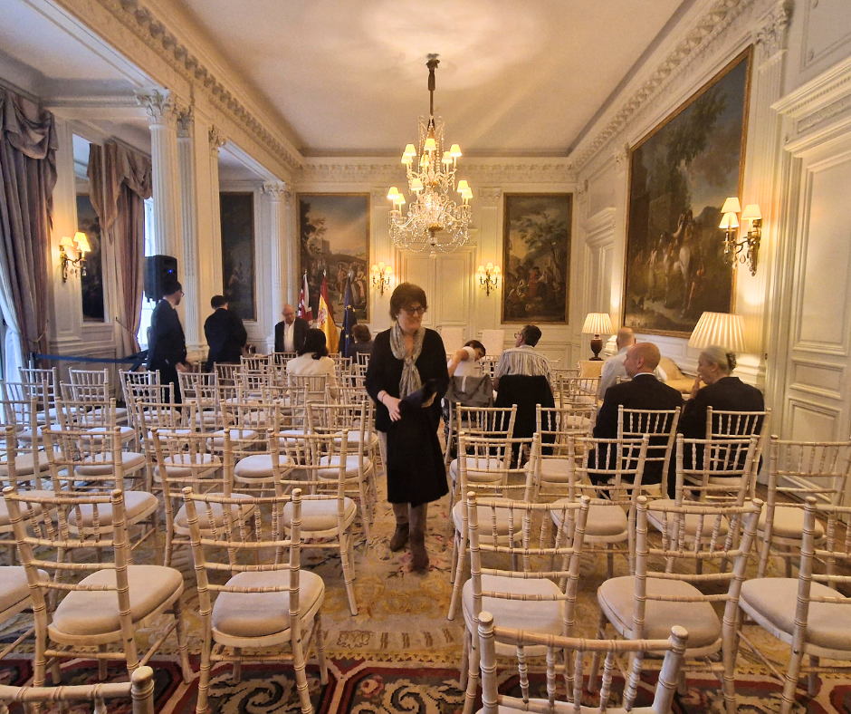 A woman stands in a room with rows of chairs