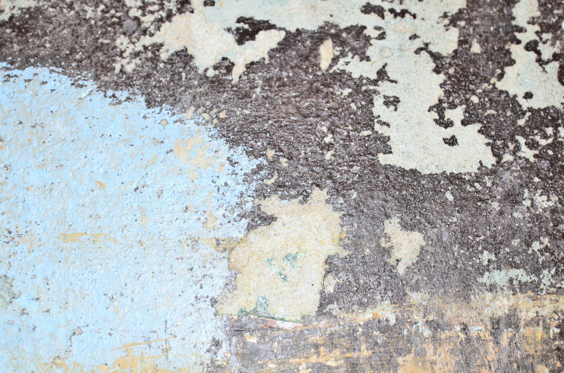 A close up of a rusty metal surface with peeling paint
