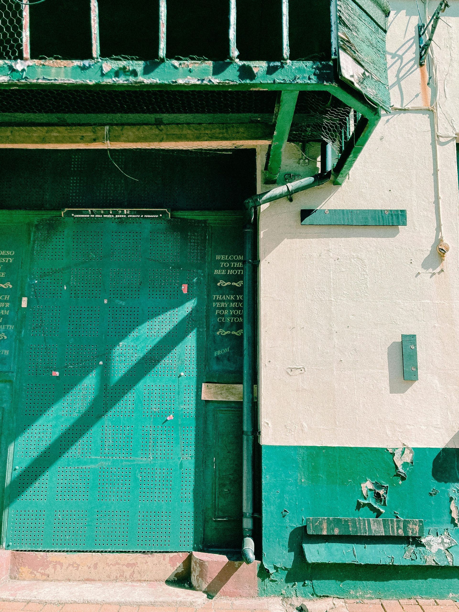 A green and white building with a green door