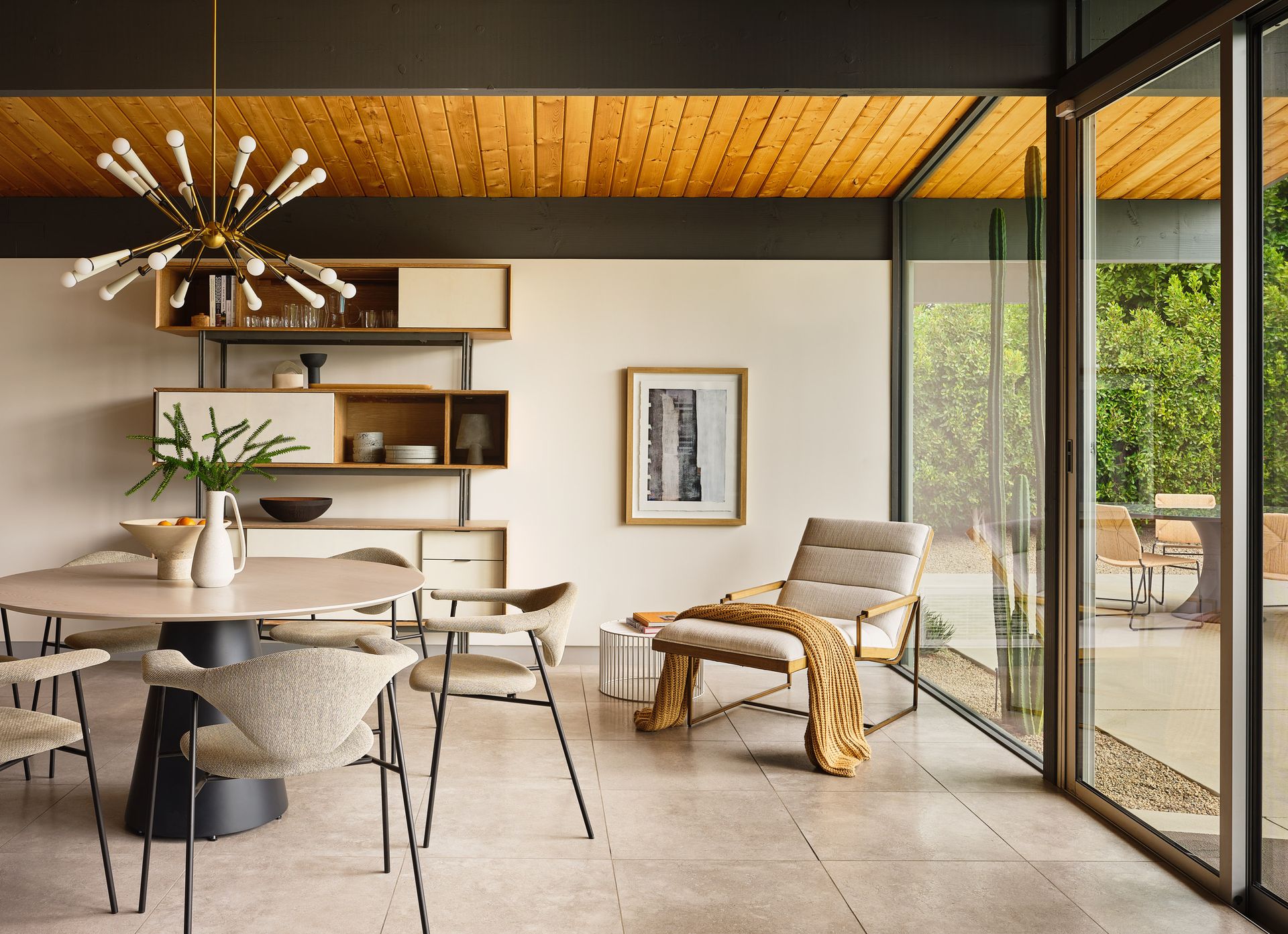 A living room with a table and chairs and a large window.