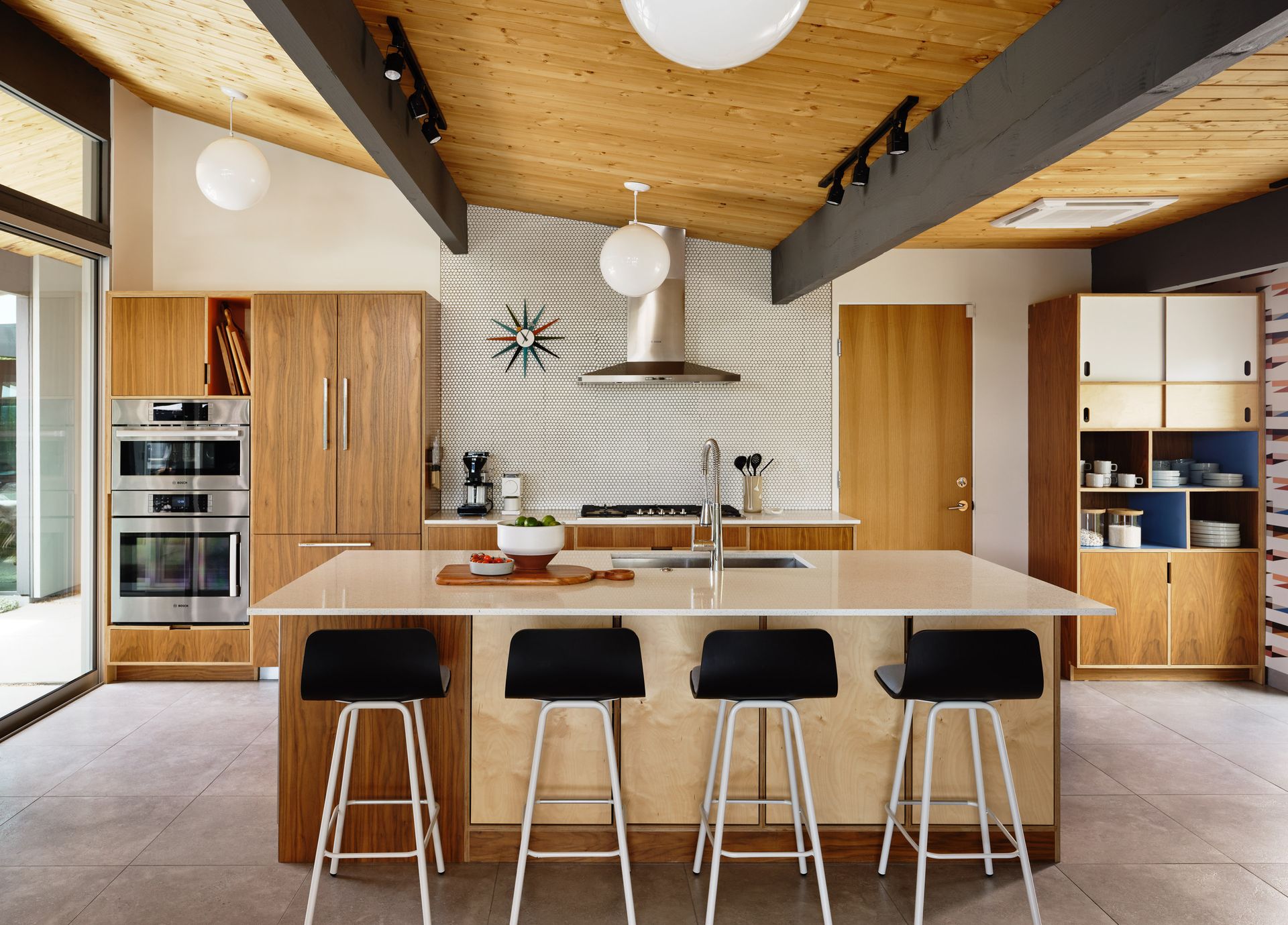 A living room with a table and chairs and a large window.