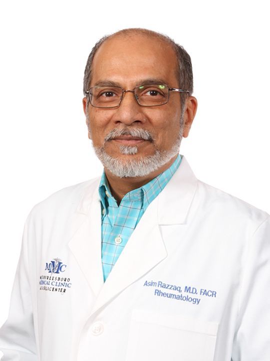 A man with a beard and glasses is wearing a white lab coat.