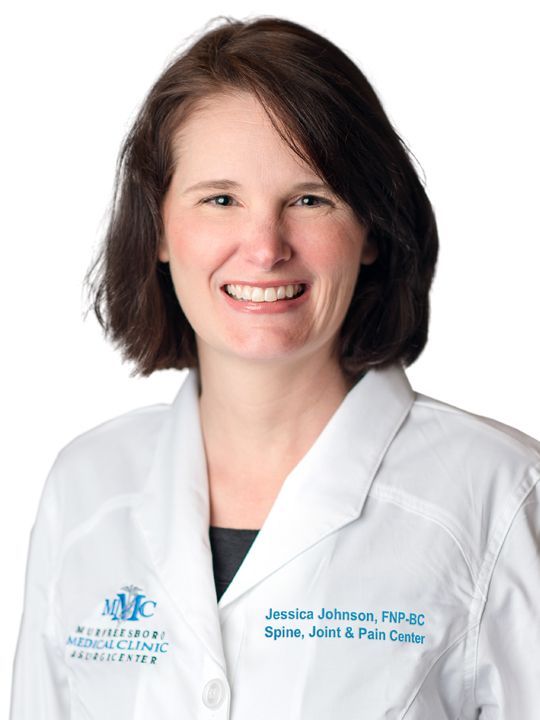 A woman in a white lab coat is smiling for the camera