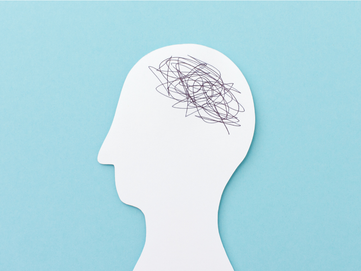 A silhouette of a person 's head with a messy brain drawn on it.