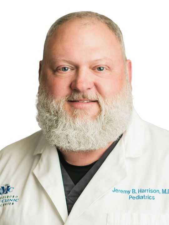 A man with a beard is wearing a white lab coat