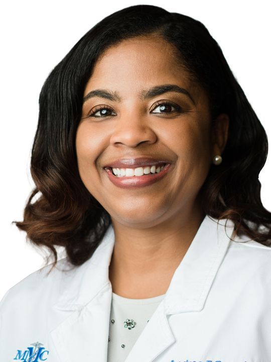 A woman wearing a white lab coat with mvc on it