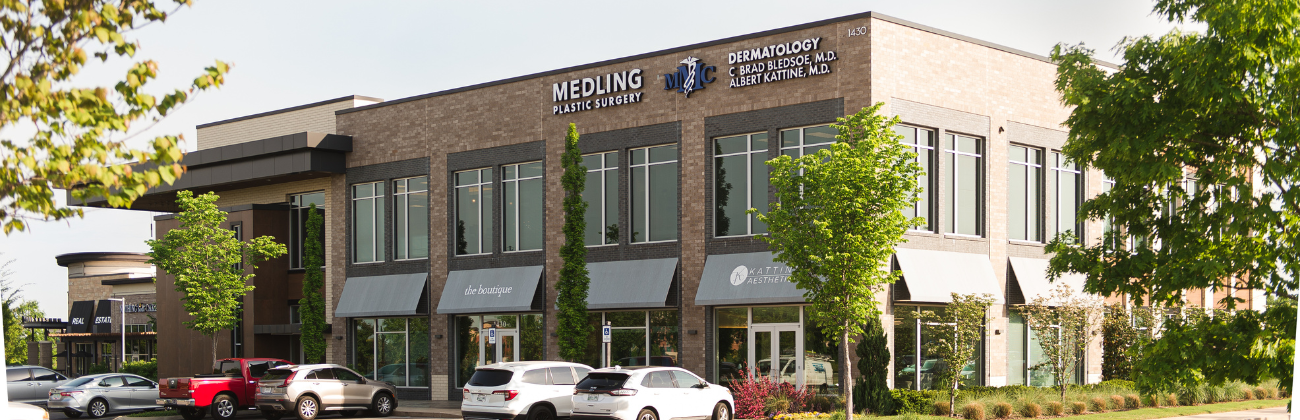 A large brick building with cars parked in front of it.