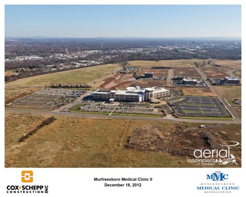 An aerial view of a large building in the middle of a field.