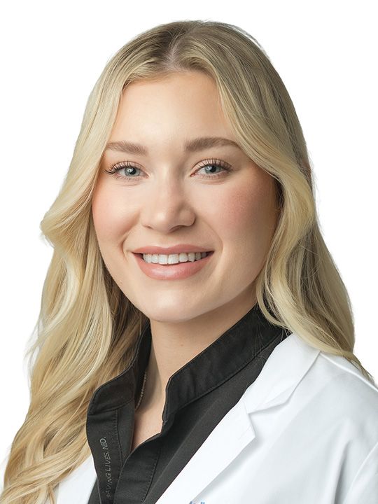 A smiling woman wearing glasses and a white lab coat