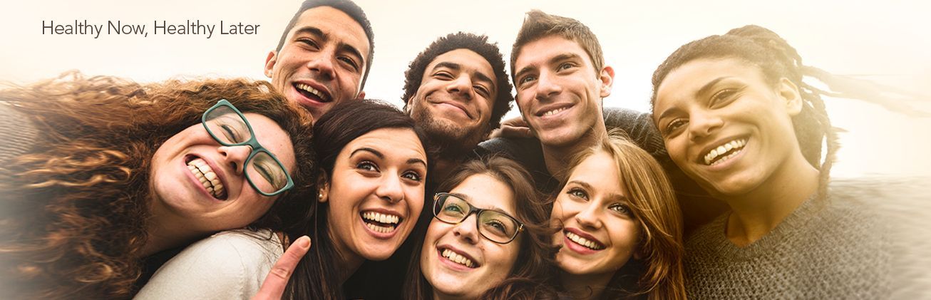 A group of young people are posing for a picture together and smiling.