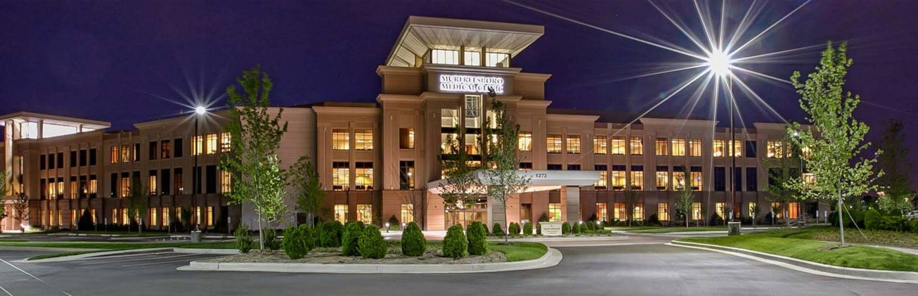 A large building with a lot of windows is lit up at night