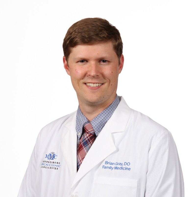 A man wearing a white coat with the name brian on it