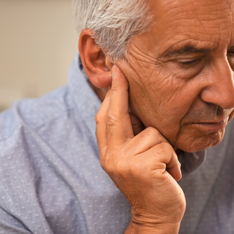 A close up of a man 's face with his hand on his chin