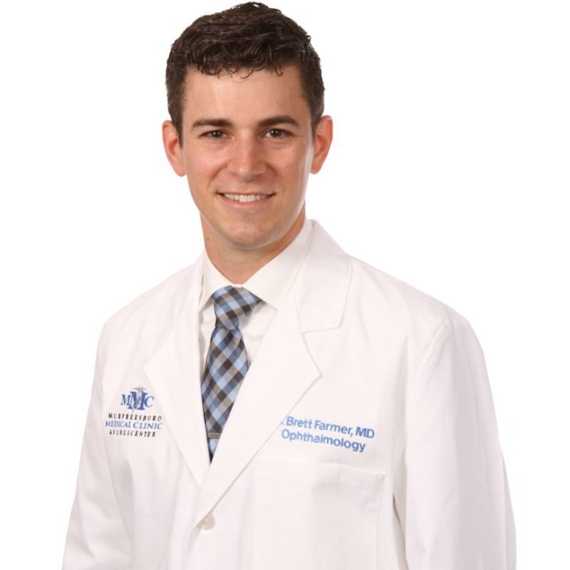 A man in a white coat and tie is a ophthalmologist
