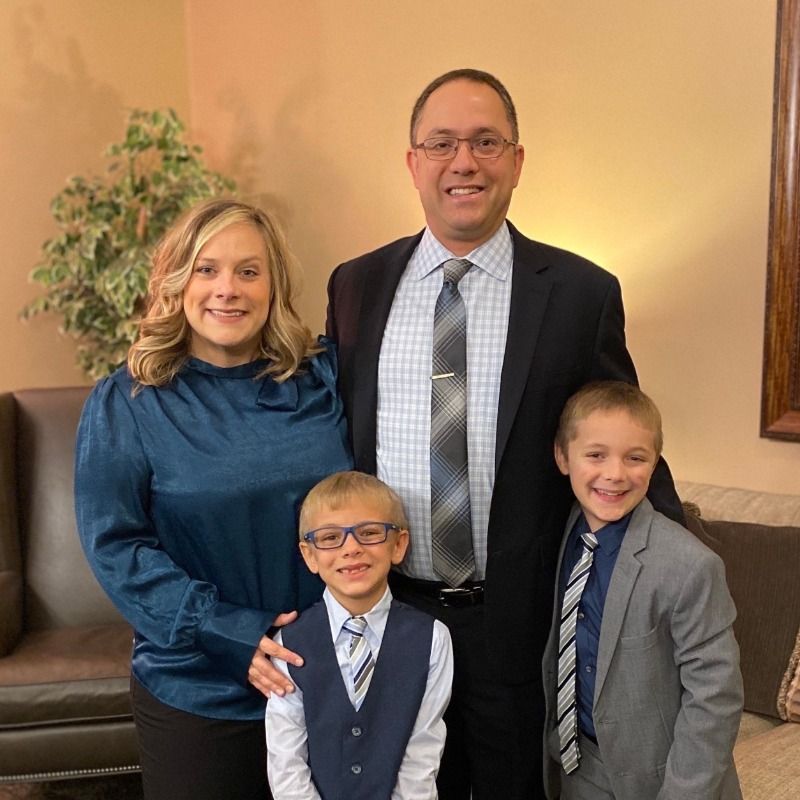 A family is posing for a picture in a living room.
