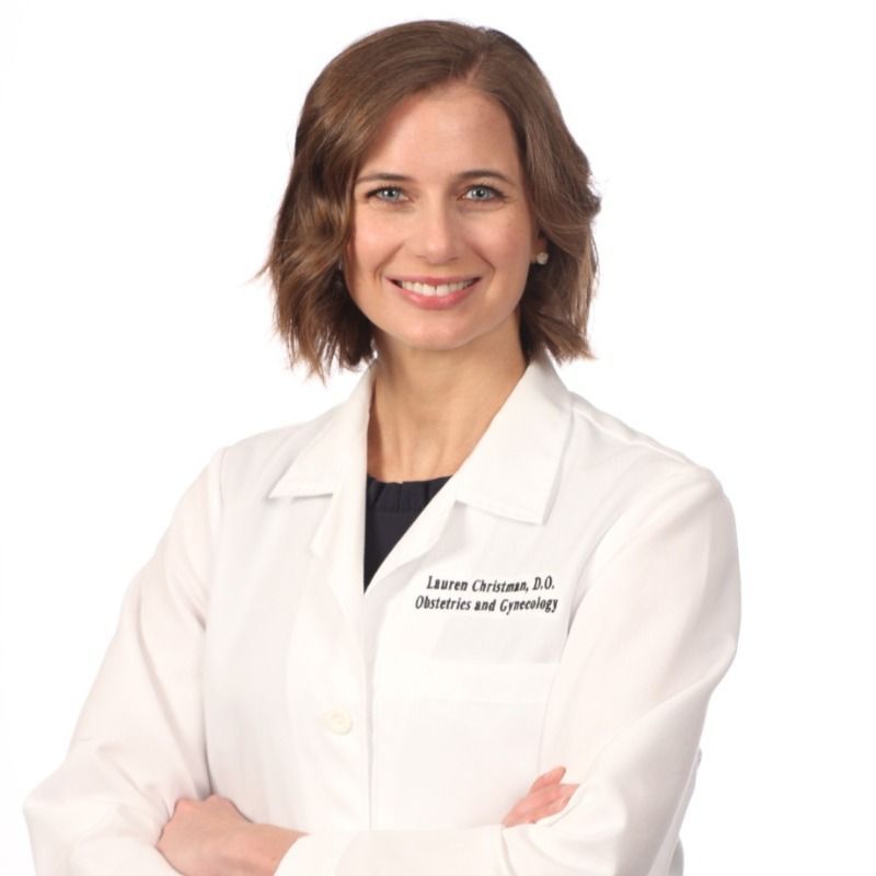 A woman wearing a white lab coat with the name lawrence on it