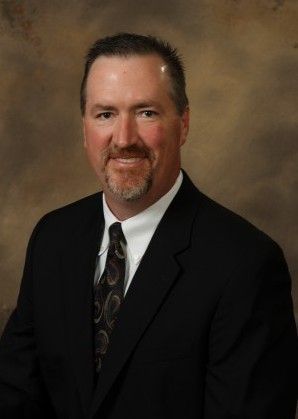 A man in a suit and tie is smiling for the camera