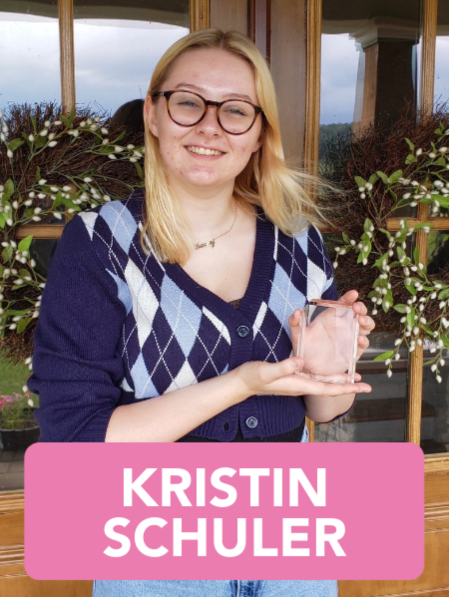 Kristin schuler is holding a glass in her hand