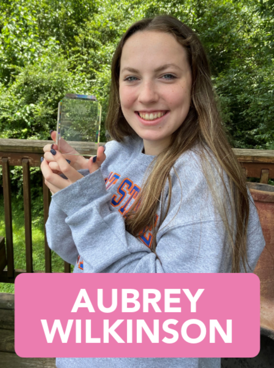 A young woman is holding a glass trophy in her hands.
