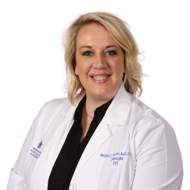 A woman wearing a white lab coat with the name megan on it