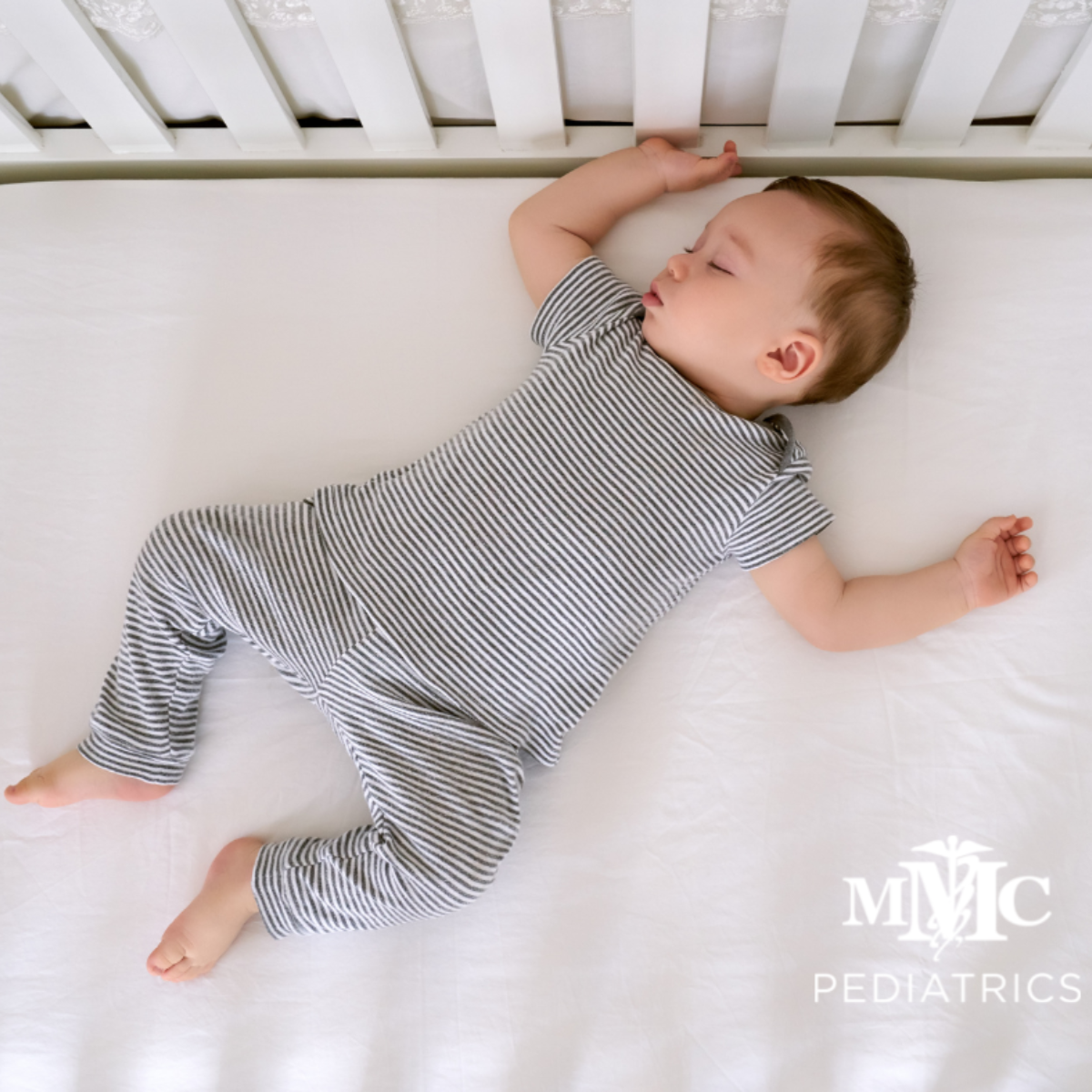 A baby is laying in a crib with a logo for mmc pediatrics