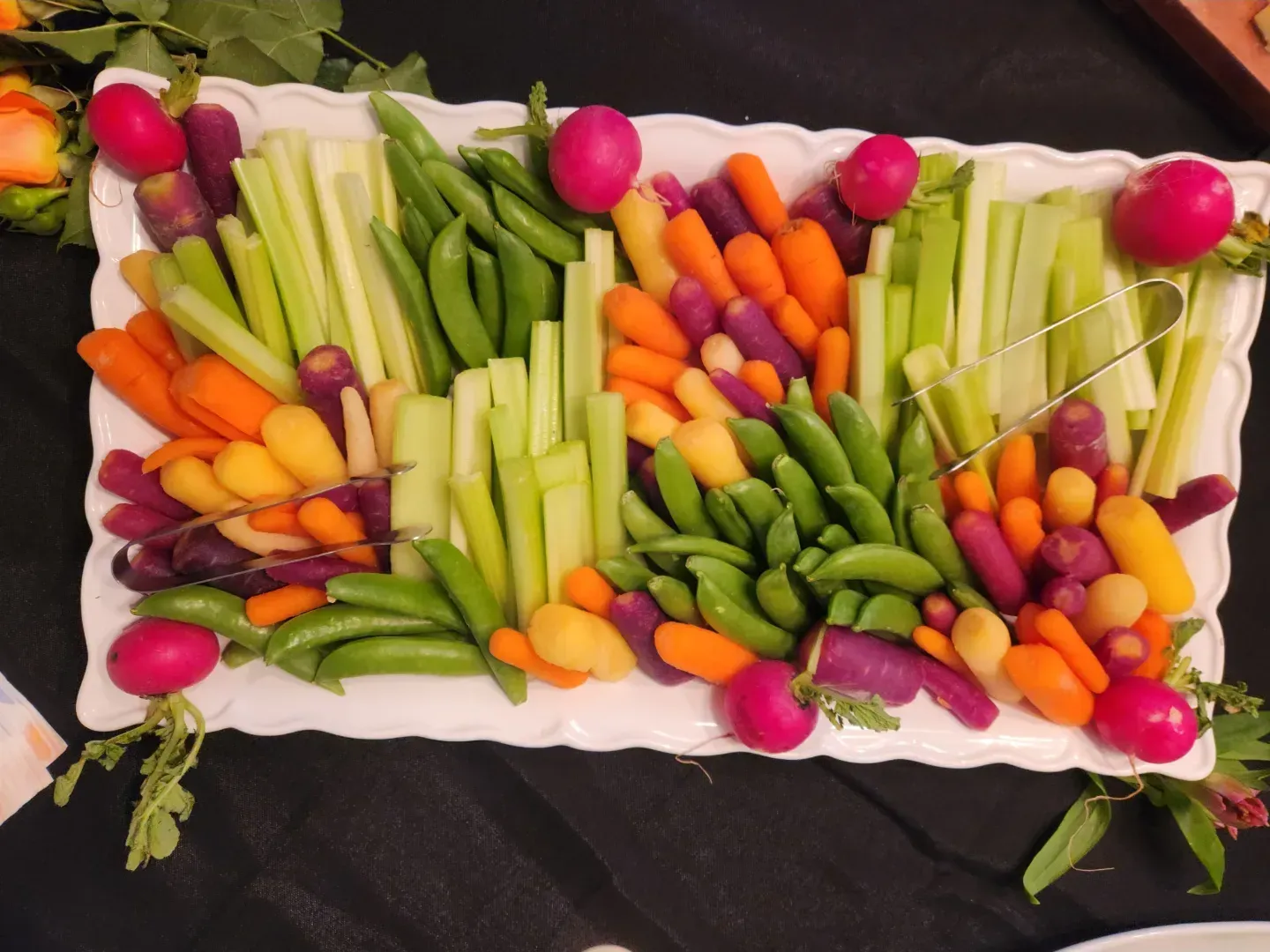 A tray of vegetables including carrots celery and radishes