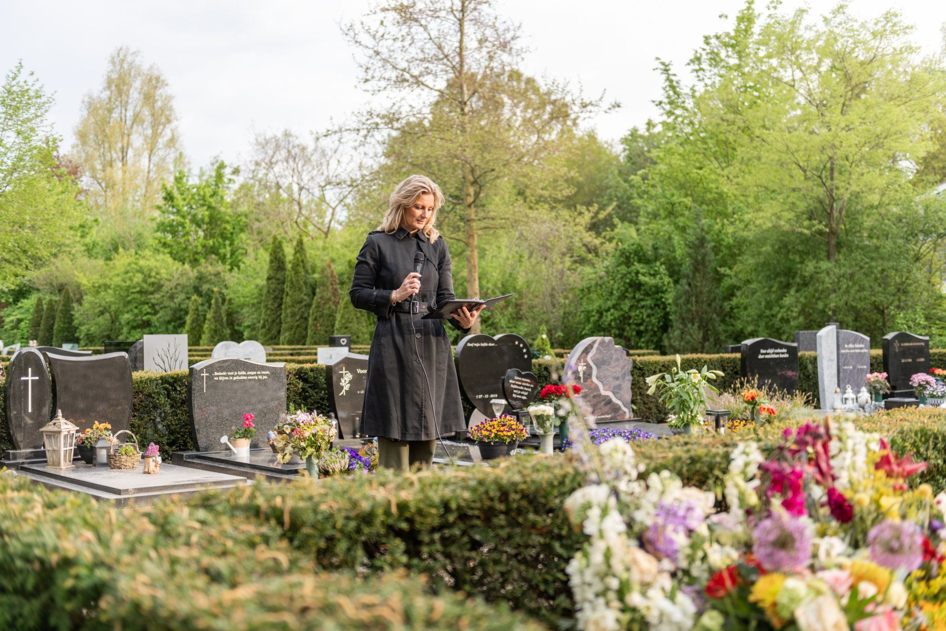 Een vrouw, Allison Knobben, Uitvaartplanner, staat op een begraafplaats en spreekt liefdevolle afscheidswoorden uit.