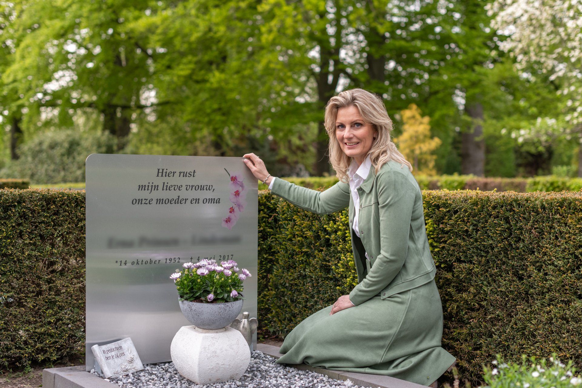 Allison knielt voor een graf op een begraafplaats. Begrafenis monument. Grafmonument.
