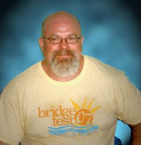 A man with glasses and a beard is wearing a shirt that says bridge fest 07