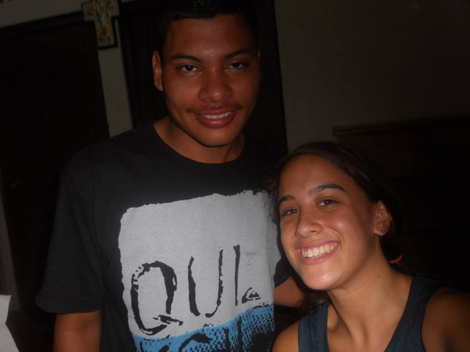 A man and a woman are posing for a picture and the man is wearing a quiksilver shirt